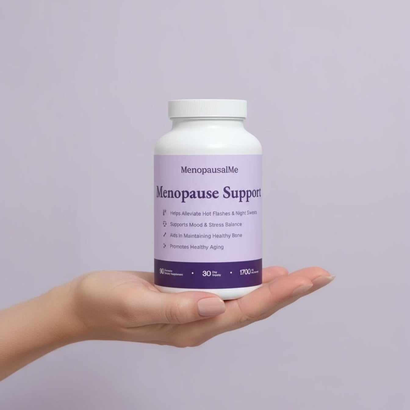 Hand holding a bottle of Menopause Support supplement against a light purple background